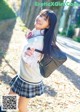 A young woman in a school uniform posing for a picture.