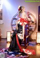 A woman in a black and red kimono sitting on a chair.