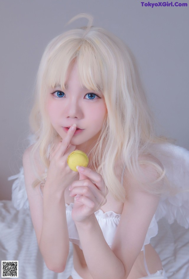 A woman with long blonde hair holding a lemon in her hand.