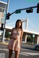 A woman standing in the middle of a street next to a traffic light.