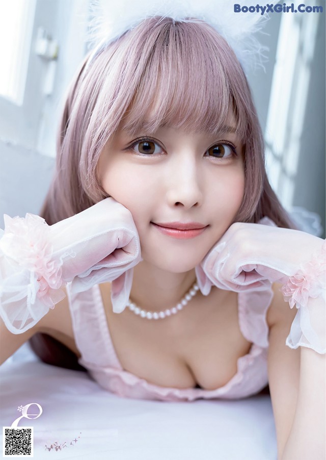 A woman in a pink dress and white gloves posing for a picture.