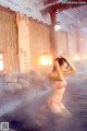 A woman in a bikini standing in a hot spring.